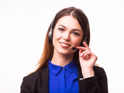 a smiling young customer service girl with a headset at her workplace