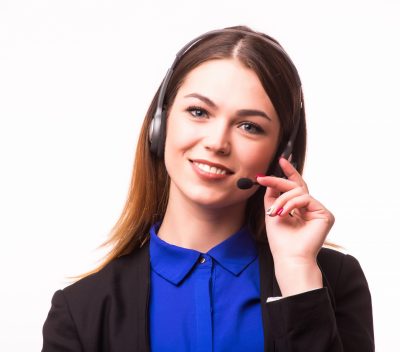 a smiling young customer service girl with a headset at her workplace